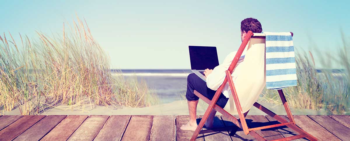 Man with laptop on a jetty